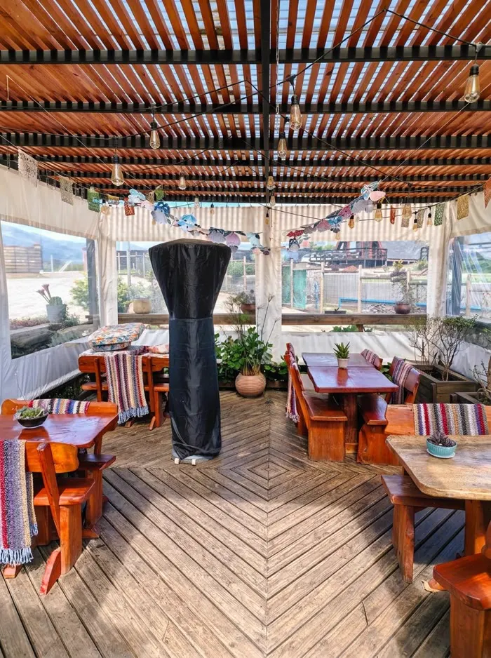 Terraza techada con mesas de madera